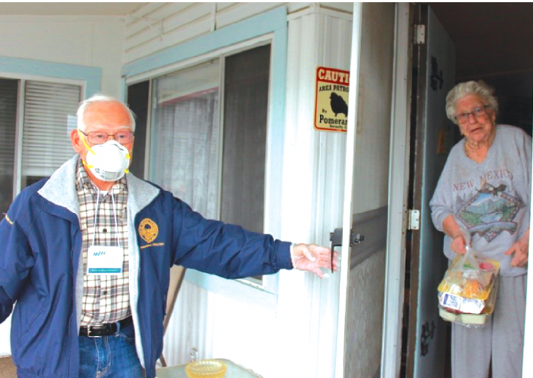 Meals on Wheels OC Home Delivery Volunteer delivers meals to client at her home.