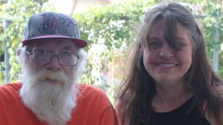 Older man with walker and woman standing
